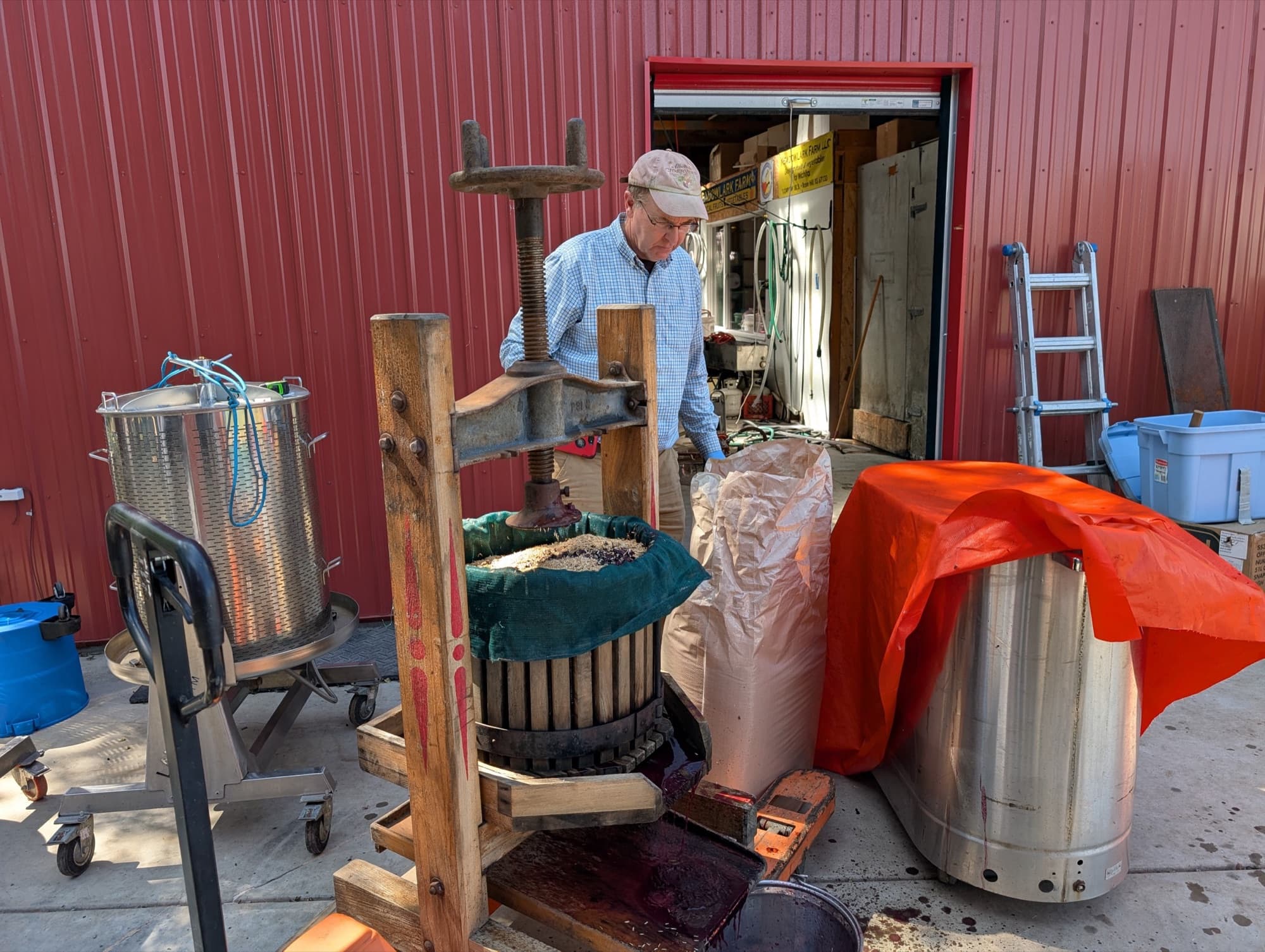 A Meadowlark founder working the cider press